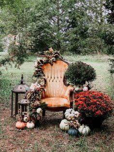 an old chair is surrounded by pumpkins and flowers