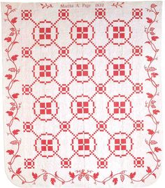 a red and white quilt with flowers on the front, in an old fashioned style