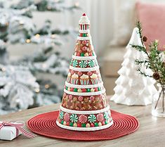 a decorated christmas tree sitting on top of a red place mat next to a white christmas tree