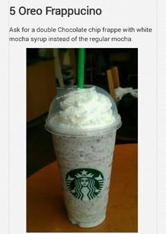 a starbucks drink with whipped cream and a green straw