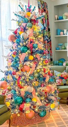 a brightly colored christmas tree in a living room with lots of ornaments on the top