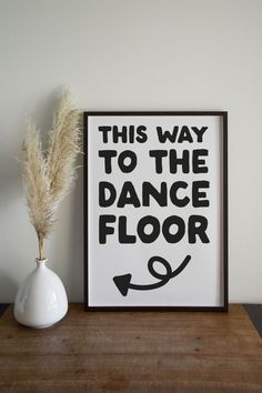 this way to the dance floor framed art print in black and white on a wooden table