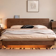 a bedroom with a bed, nightstands and pictures on the wall above it is shown