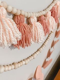 a string of tassels hanging from the side of a wall next to wooden beads