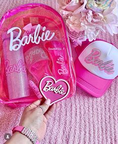 a person holding a pink barbie backpack and hat