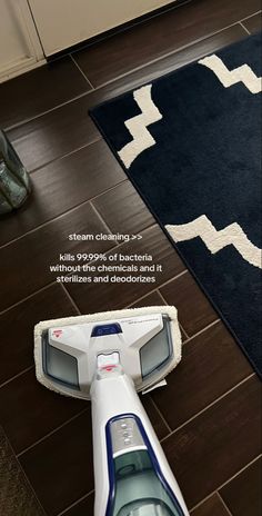 a close up of a vacuum on the floor with a rug in front of it