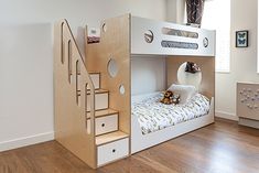 a child's bedroom with bunk bed, stairs and storage space in the corner