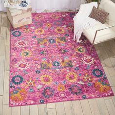 a bright pink rug with an ornate design on the front and back side, in a room