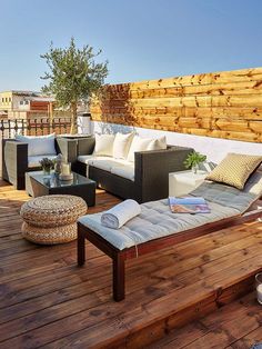 a wooden deck with couches and tables on it