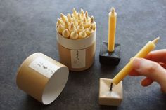 a person is holding a candle in front of some sort of matchbox with matches