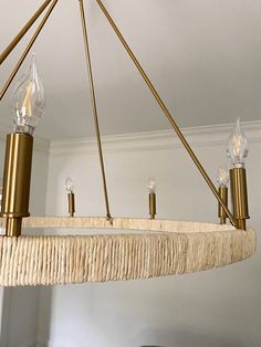 a chandelier hanging from the ceiling in a room with white walls and wood flooring