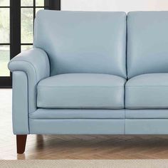 a light blue leather couch in front of a window