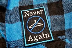 there is a patch that says never again on a blue and black checkered shirt