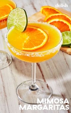 two margaritas are garnished with lime and orange slices