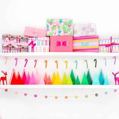 a shelf filled with lots of different types of wrapping paper and gift boxes on top of it