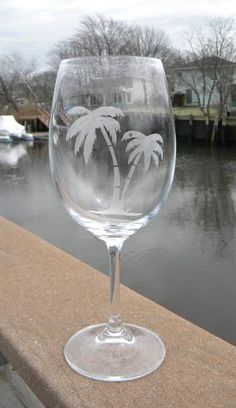 a wine glass with palm trees etched on it