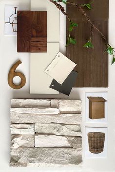 materials scheme showing a warm modern cottage design using split face stone veneer in a white color, creamy white shiplap siding, a natural wood door and faux wood shake shingles in dark colors, a gas lantern in multiple metal finishes, brass house numbers a brass mailbox and a woven basket planter Stacked Stone Veneer Exterior, Urbane Bronze Siding Exterior, Natural Linen Siding Exterior, Cedar And Stone Exterior, Modern Stone Mailbox Ideas, Natural Linen Exterior House, Stone And Shake Exterior, Sherwin Williams Natural Linen Exterior, Natural Stone Exterior House