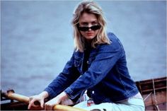 a woman riding on the back of a wooden boat