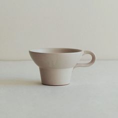 a white cup sitting on top of a table