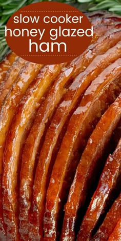 sliced honey glazed ham on a platter with rosemary sprigs in the background