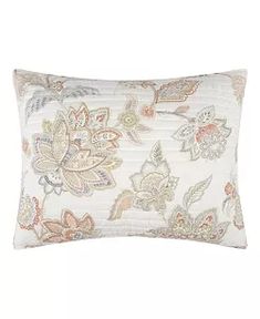 a white pillow with floral designs on the front and back, sitting against a white background