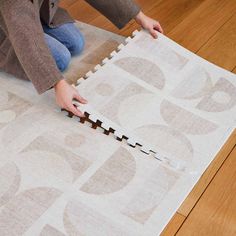 a child is playing with puzzle pieces on the floor in front of a carpeted area