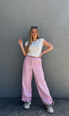 FINAL SALE, NO RETURNS 3 words: pink. parachute. pants. You will LOVE these! These light pink parachute pants with a drawstring waistband and ankle are able to adjust to your liking. Pair it with a baby tee, corset, or even your favorite sweatshirt on the cooler days! Model is 5'6" with a 32 bust, 27" waist, 40" hips, and wearing a small. Model usually wears size 2/4. This item runs true to size! Pink Cotton Pants Outfit, Pink Running Shoes Outfit, Pink Bottoms Outfit, Pink Cargo Pants Outfits, Pink Parachute Pants, Outfits Uni, Parachute Pants Outfit, Pink Pants Outfit, Light Pink Pants