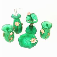 four pieces of green glass with flowers on them