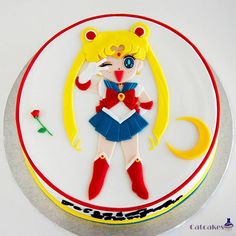 there is a cake that looks like a sailor girl on the plate, and has been decorated with fondant