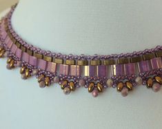 a close up of a purple necklace on a mannequin headdress with beads