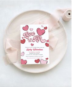 a white plate topped with a pink and red valentine's day card