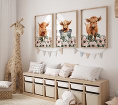 a room with three pictures on the wall and two stuffed animals hanging from the ceiling