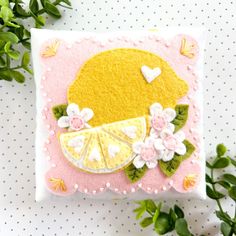 a pillow with a lemon slice and flowers on it