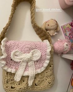 a crocheted purse sitting on top of a table next to a stuffed animal