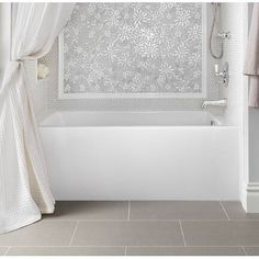 a white bath tub sitting next to a shower curtain