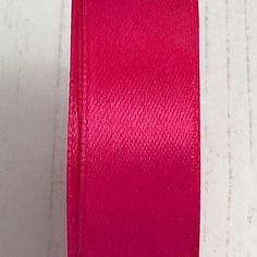 a spool of bright pink satin ribbon