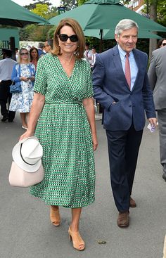 a woman in a green dress and a man in a blue suit are walking down the street