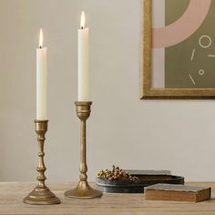 two candles sitting on top of a wooden table