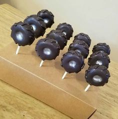 chocolate covered lollipops sitting on top of a cardboard box