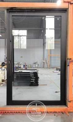 the inside of a building that is being built with glass doors and steel bars on each side