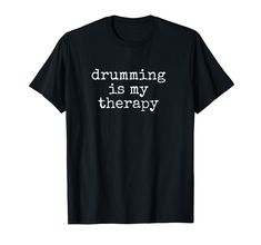 a black t - shirt with the words drumming is my therapy on it's chest