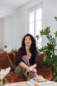 a woman sitting on top of a brown couch