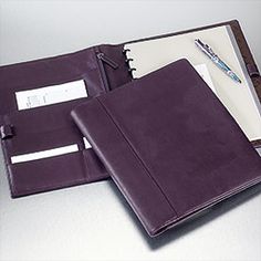 a black leather folder with pen and notepad