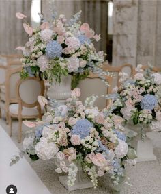 there are many flowers in the vases on the tables at this wedding ceremony,