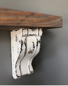 a close up of a wooden shelf with white paint on it