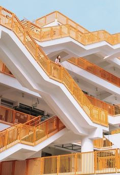 an apartment building with multiple balconies and yellow railings on the second floor