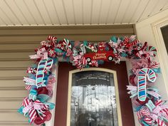 the front door is decorated with red, white and blue ribbon wreaths on it