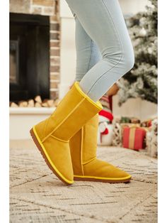 Stay warm and stylish with SMAIBULUN Ugg's Classic Suede Mid-Length boots in this unique yellow exclusively. These cozy boots feature high-quality suede material for comfort and a unique mid-length style for a standout look. Perfect for keeping your feet warm and your style on point all winter long. 1'' heel 11.5'' shaft 15.5'' circumference Pull-on Suede upper Faux fur lining Man-made sole Trendy Yellow Winter Boots, Yellow Fitted Boots With Round Toe, Yellow Fitted Casual Boots, Casual Yellow Winter Boots, Yellow Casual Boots, Cozy Boots, Reindeer Headband, Ugg Classic, Suede Material