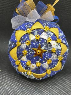 a blue ornament with gold stars and moon decorations on it's side