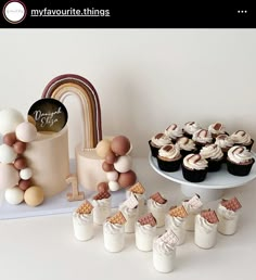 a table topped with cupcakes next to a cake and other dessert items on top of a plate